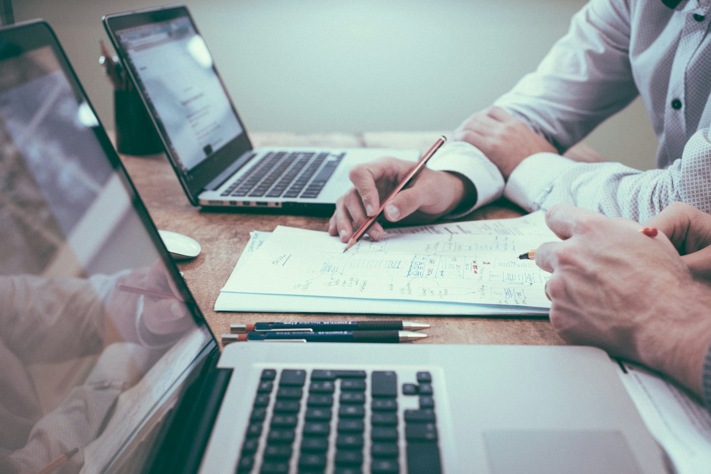 Due professionisti che collaborano su documenti e laptop.