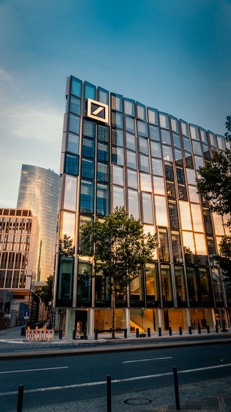 Edificio moderno con logo aziendale che riflette il tramonto.
